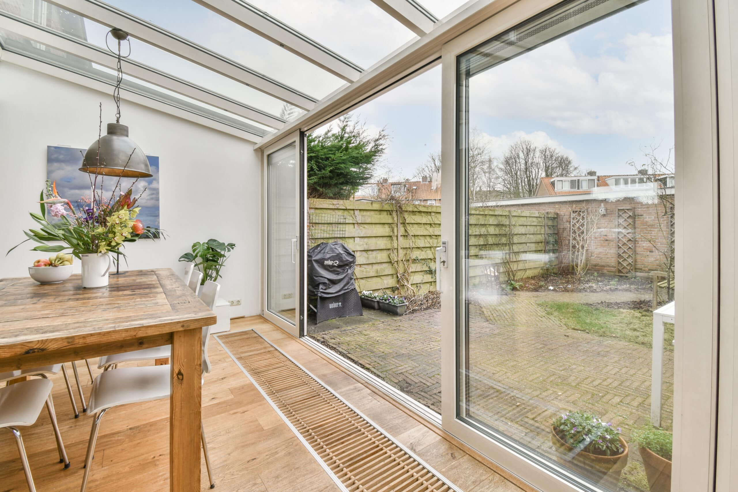 Amsterdam, Netherlands - 10 April, 2021: an outside area with a table, chairs and a bench in the middle part of the room looking out to the garden